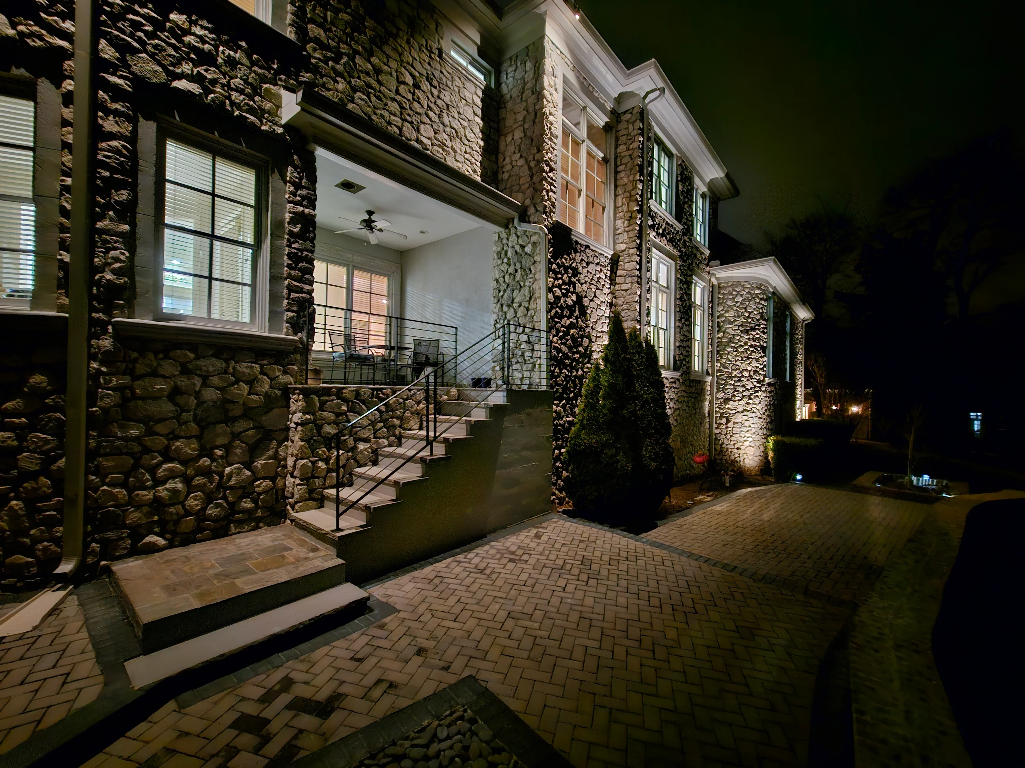 A Franklin, TN home at night with low-voltage LED landscape lighting illuminating the front facade, walkway, and garden beds. Warm-toned fixtures highlight the architectural roofline and mature trees in the front yard.